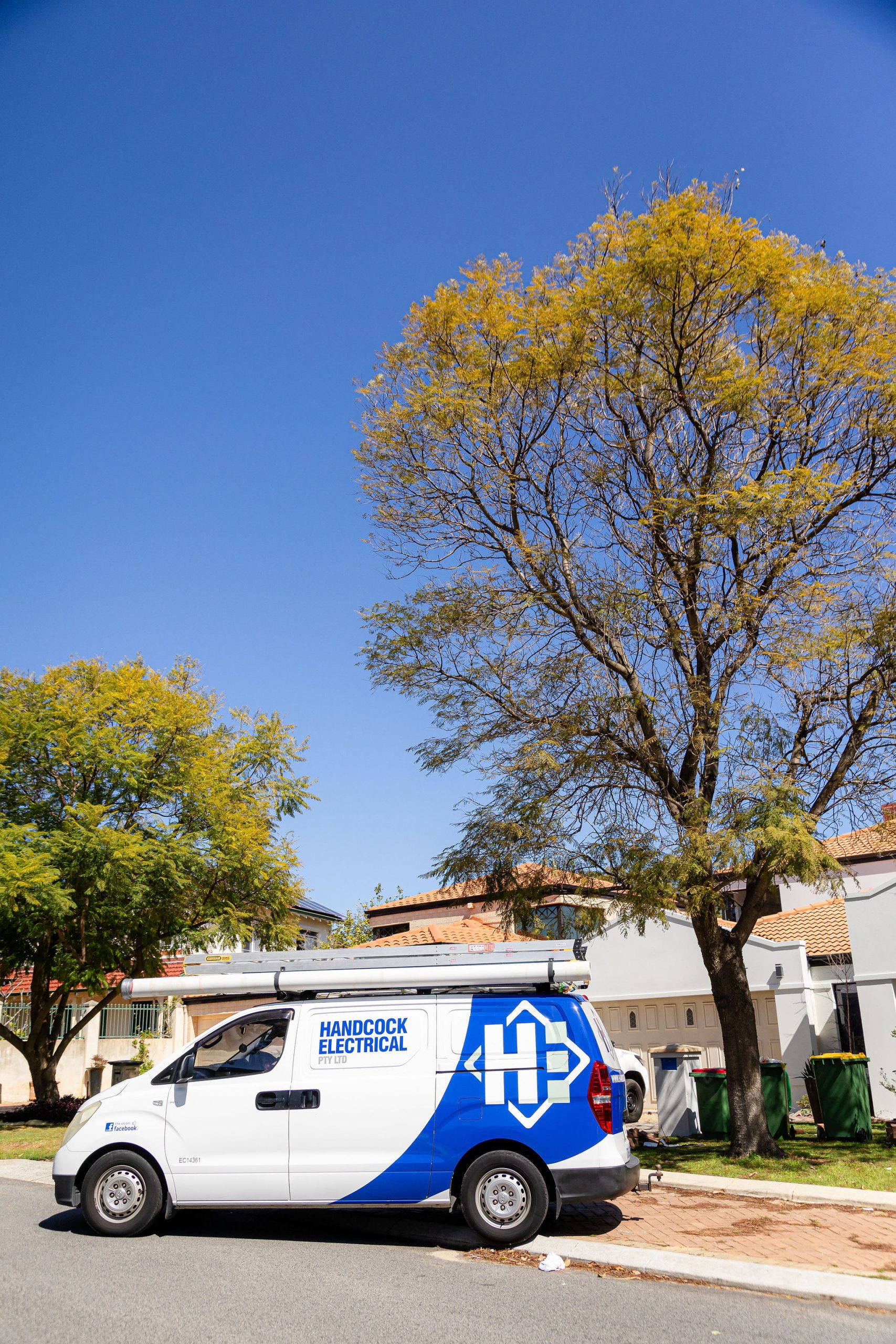 A professional electrician in Perth arrives at a residential property in a fully equipped Handcock Electrical service van, ready to provide expert electrical solutions.